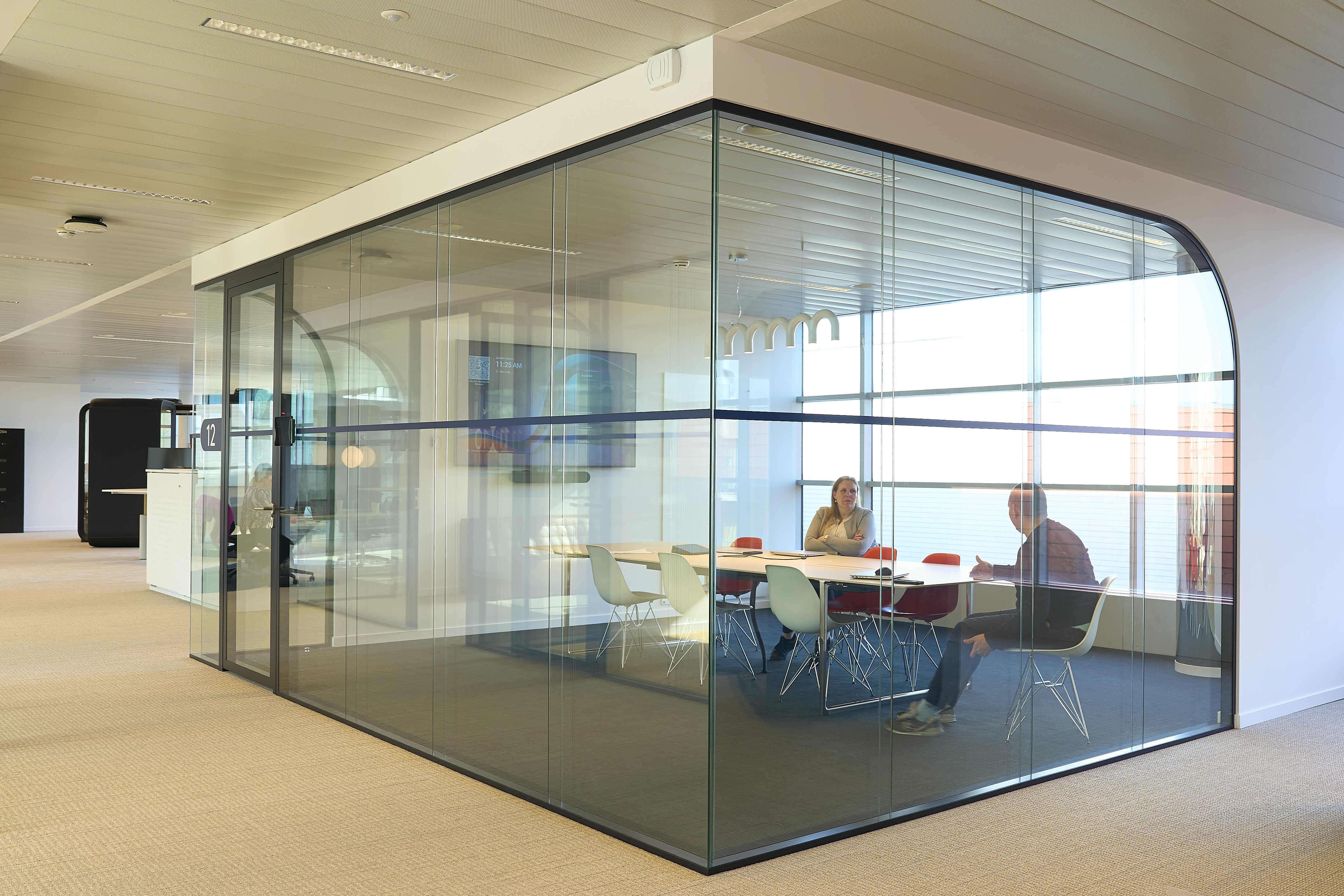 une paroi en verre avec des personnes assises à une table