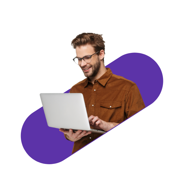 man with glasses smiling in front of a laptop