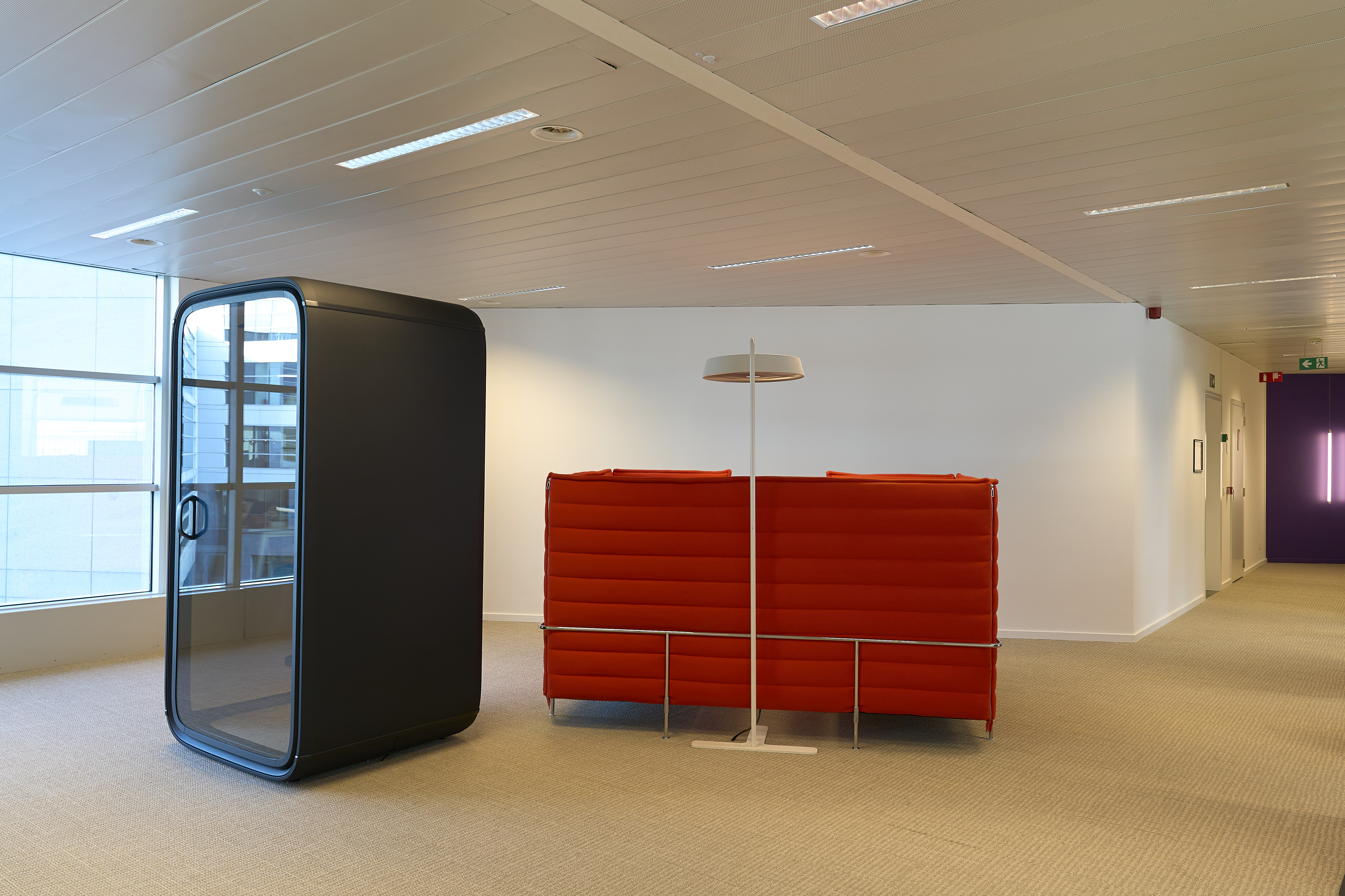 un canapé rouge et une boîte noire dans une pièce