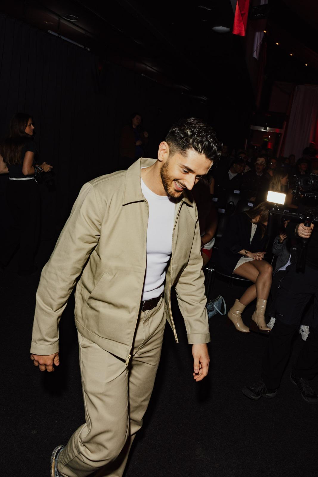 un homme en chemise blanche et veste kaki