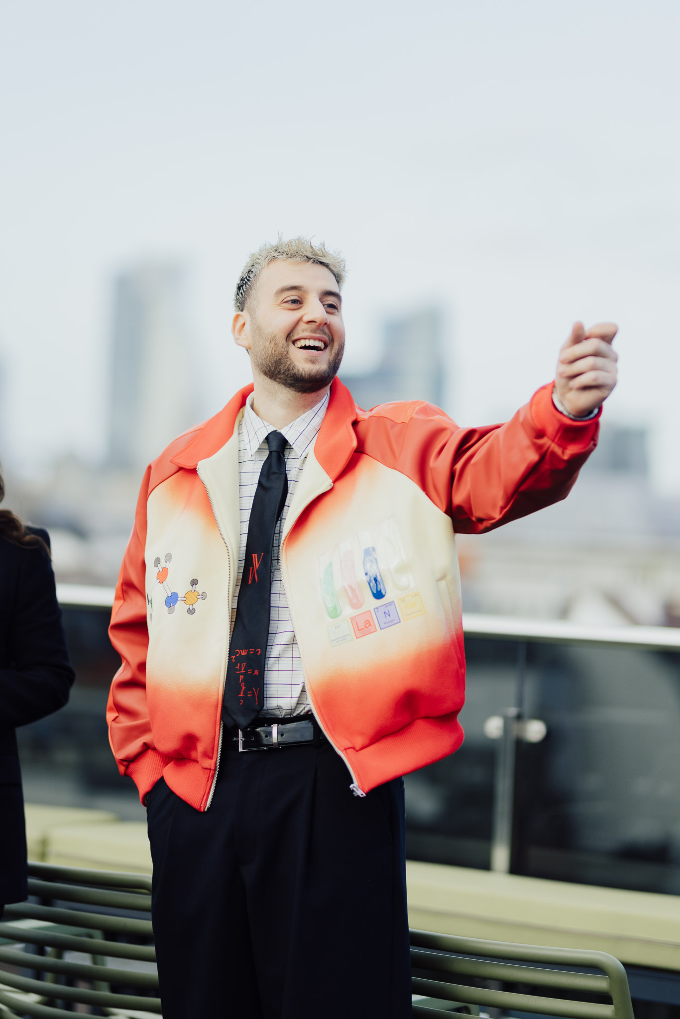 een man in een rood jasje die met zijn vinger wijst