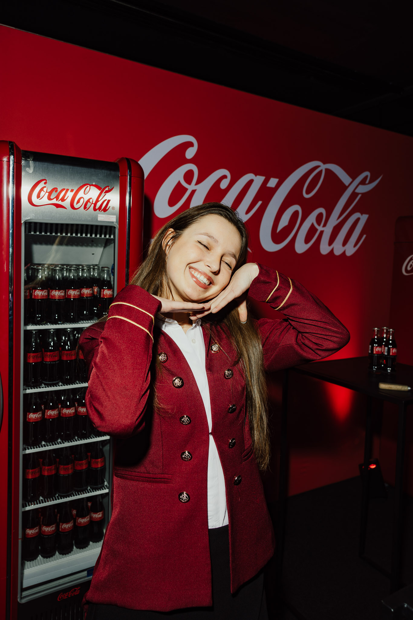 une femme souriante devant une machine à soda