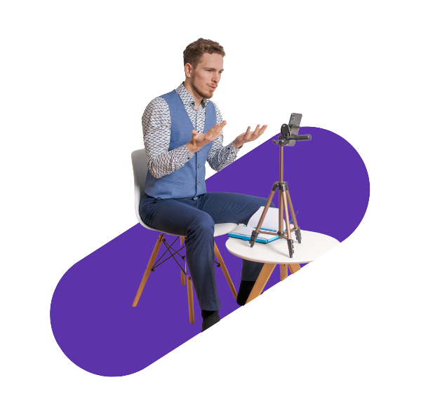 homme assis sur une chaise parlant en face de son téléphone accroché à un trépied 