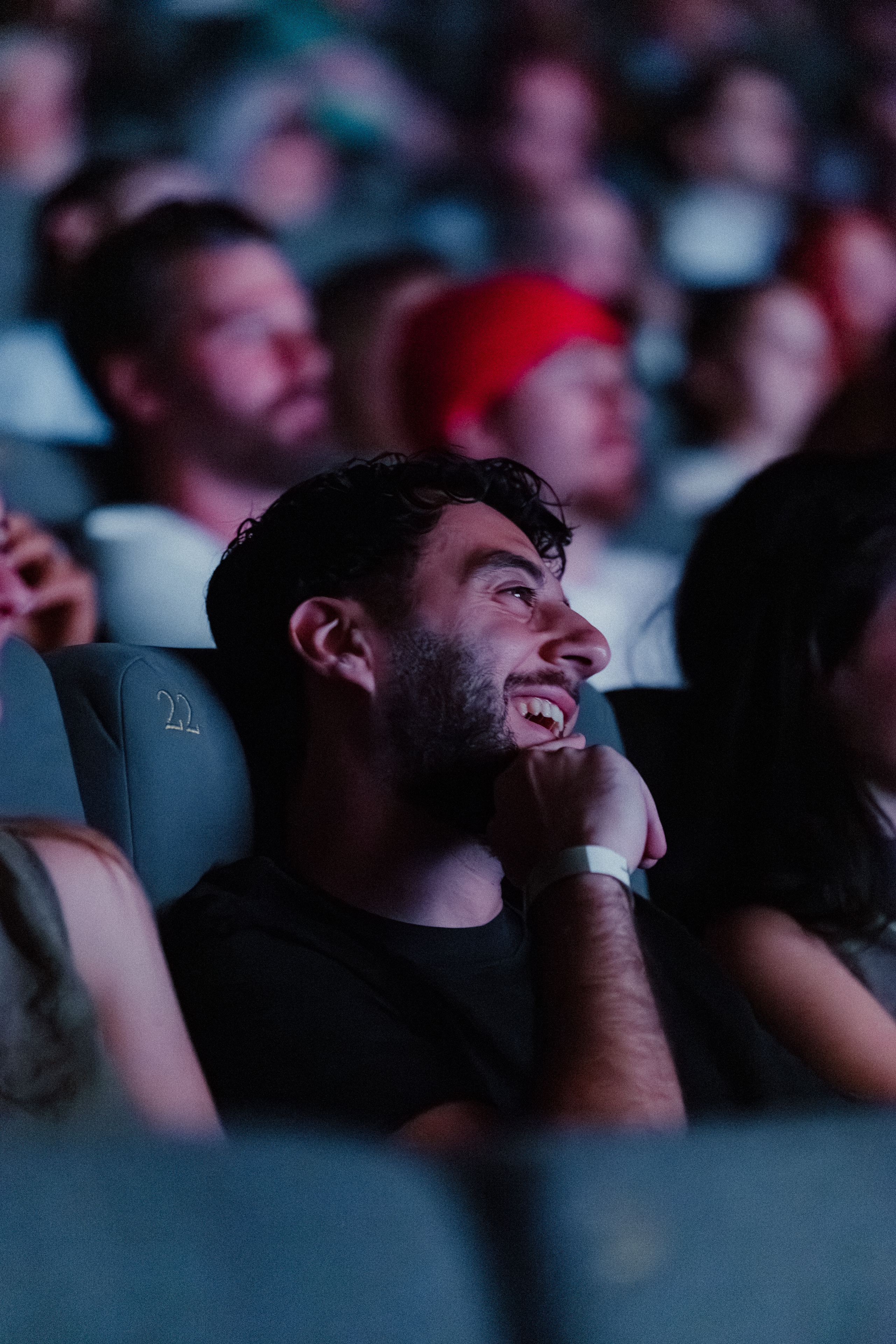 un homme souriant dans une salle de cinéma